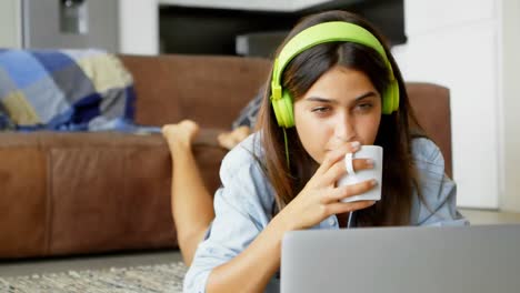 Animation-of-Caucasian-woman-with-headphones-and-drinking-over-hearts-and-thumbs-up-icons-moving