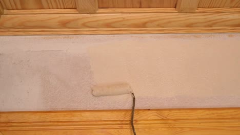 painting a wall with a paint roller