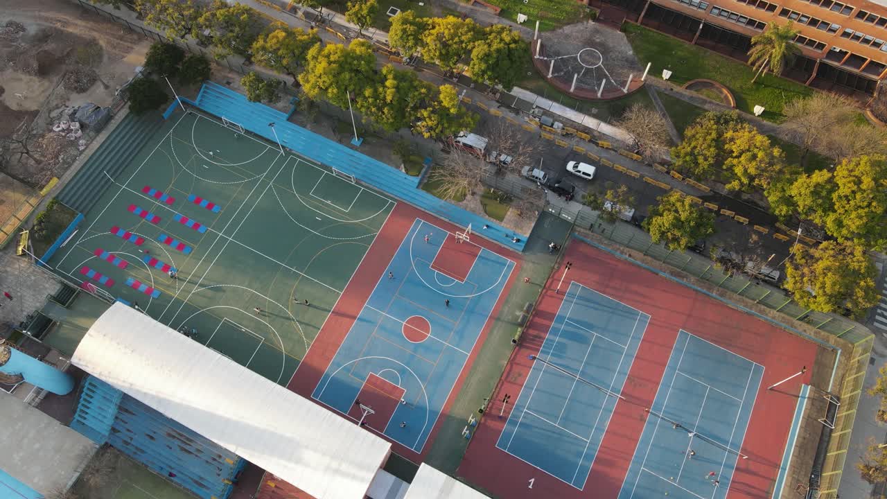 tiro aéreo de cima para baixo de jogadores jogando basquete na quadra durante o dia ensolarado, 4k
