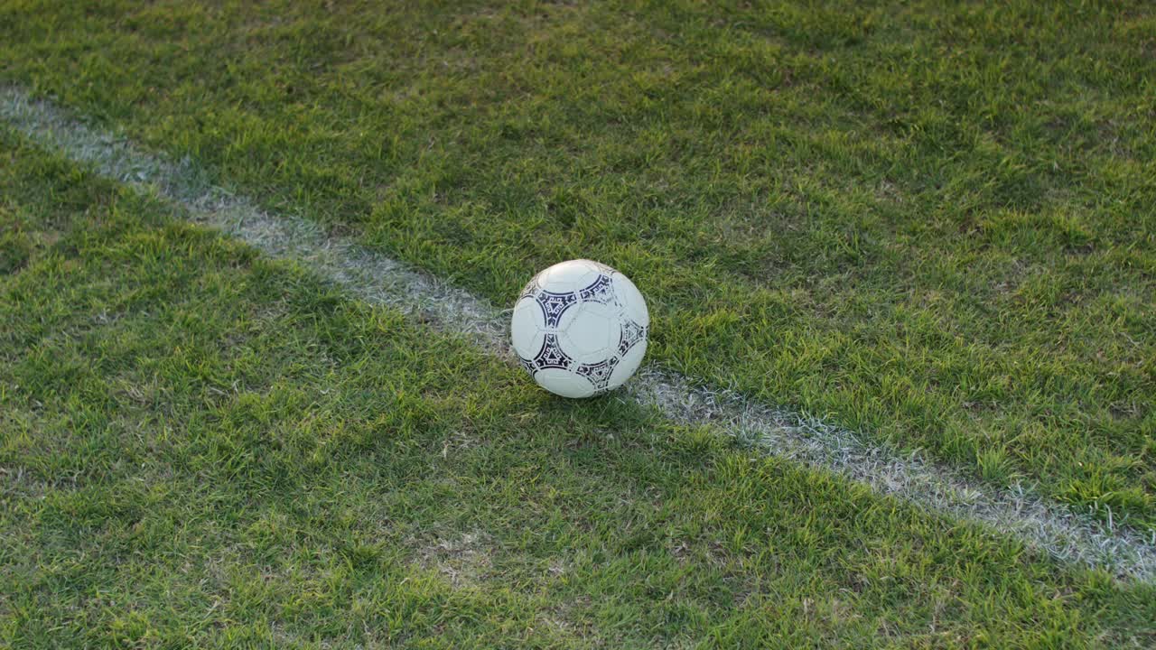 Close shot of football soccer player kicking ball on professional pitch