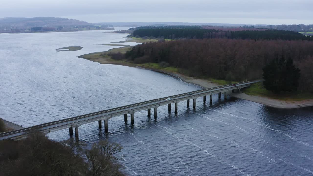 Orizzonti che si uniscono: Viaggio aereo al Ponte di Baltyboys sul fiume Liffey nelle Montagne di Wicklow, durante un viaggio serale nuvoloso.