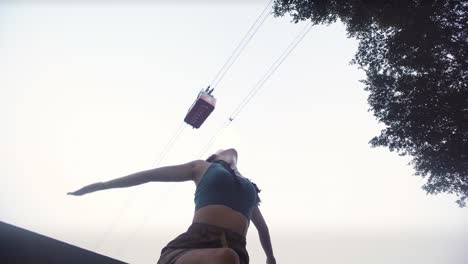 adventurous asian woman throws arms up to yangtze river cableway, chongqing