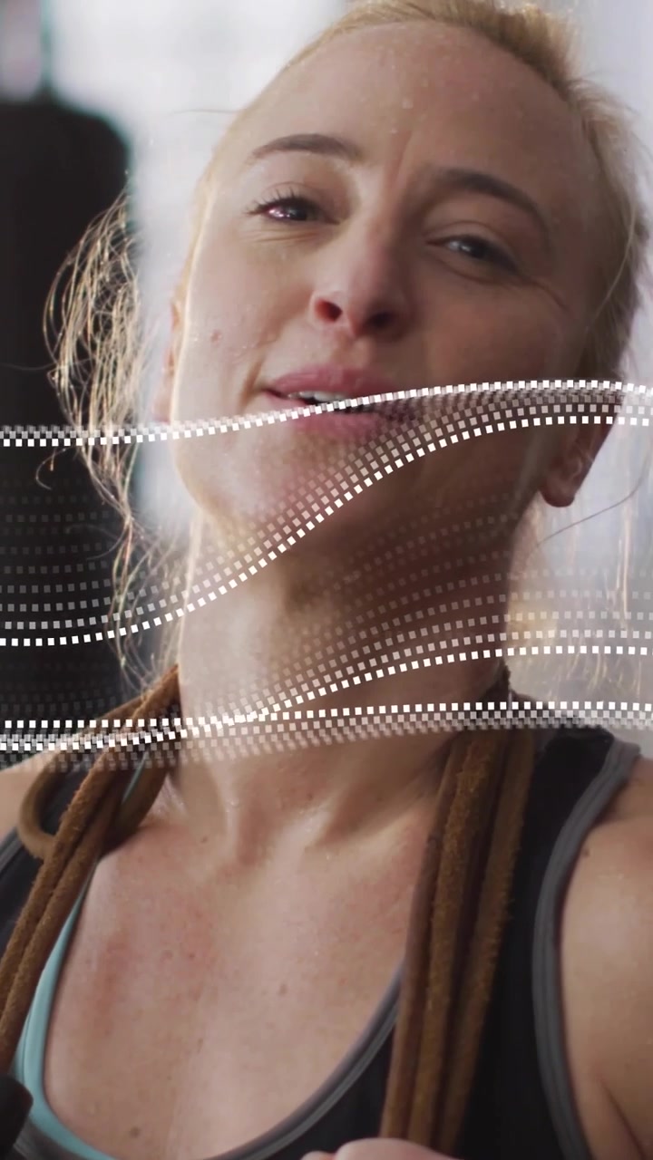 Video verticale: Donna che tiene una corda in palestra, con un'onda puntinata scintillante, che fa una pausa e riposa.