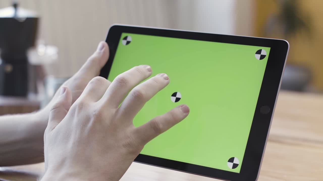 manos usando una tableta con una pantalla verde