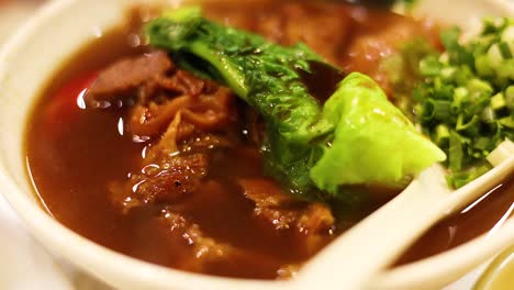 noodles with meat and greens in broth