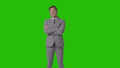 three quarter length portrait of businessman in suit against green screen smiling at camera 3