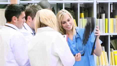 footage of medical team examining an xray in hospital