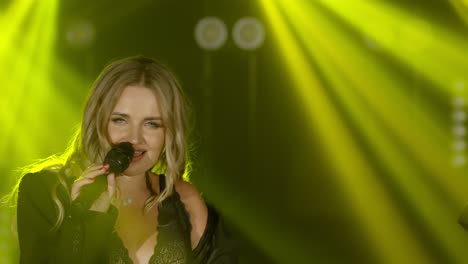 live vocal performance of emotional singer in black jacket. vocalist girl dancing, singing on stage