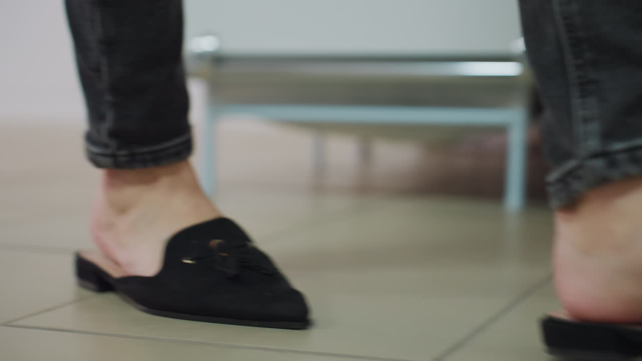 움직이는 세련된 신발, 정교한 실내 워킹 전시 중 우아한 신발 전시, 균형 잡힌 실내 활보 행사 중 자신의 세련된 신발을 선보이는 백인 여성