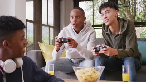 Happy-diverse-male-teenage-friends-playing-video-games-at-home,-slow-motion