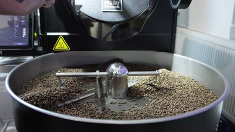 amplia visión general de los granos de café cayendo en la tostadora de tambor de metal, cámara lenta
