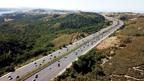 highway traffic on a summer afternoon with fog rolling over crystal springs reservoir as seen from a vista point