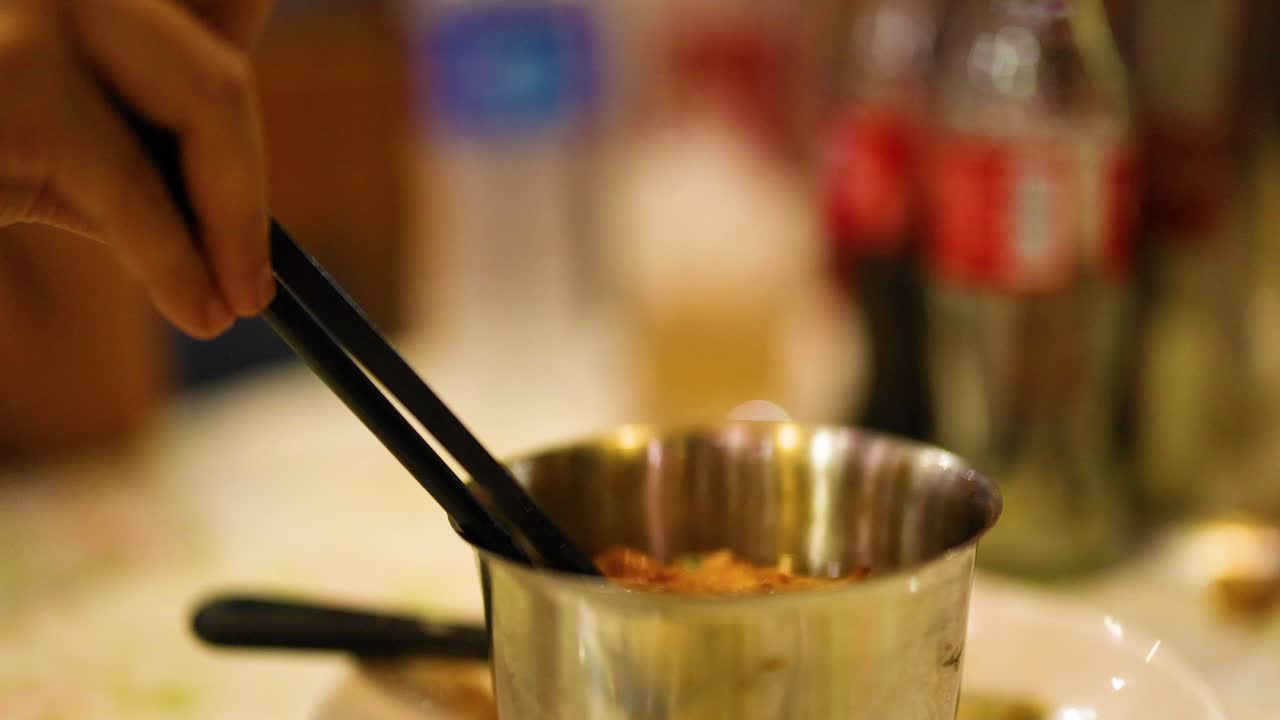 가락 들 이 비 에서 김 된 돼지고기 를 들어 올리고 있다