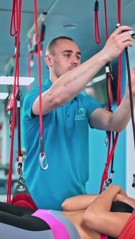 young woman doing exercises under physiotherapist supervision