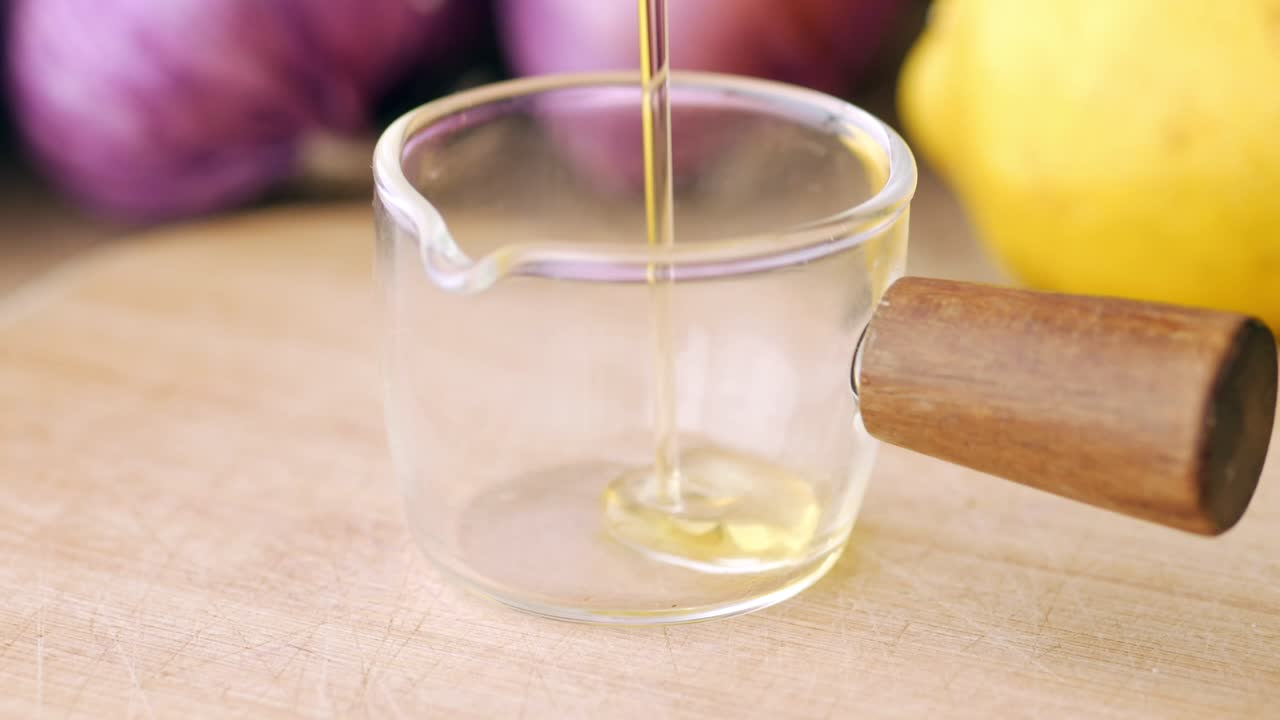 Pouring Oil into a Small Glass Measuring Cup