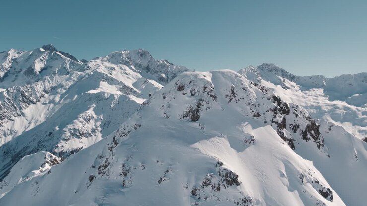 A beautiful view of mountain peaks covered in snow in the sunny winter day