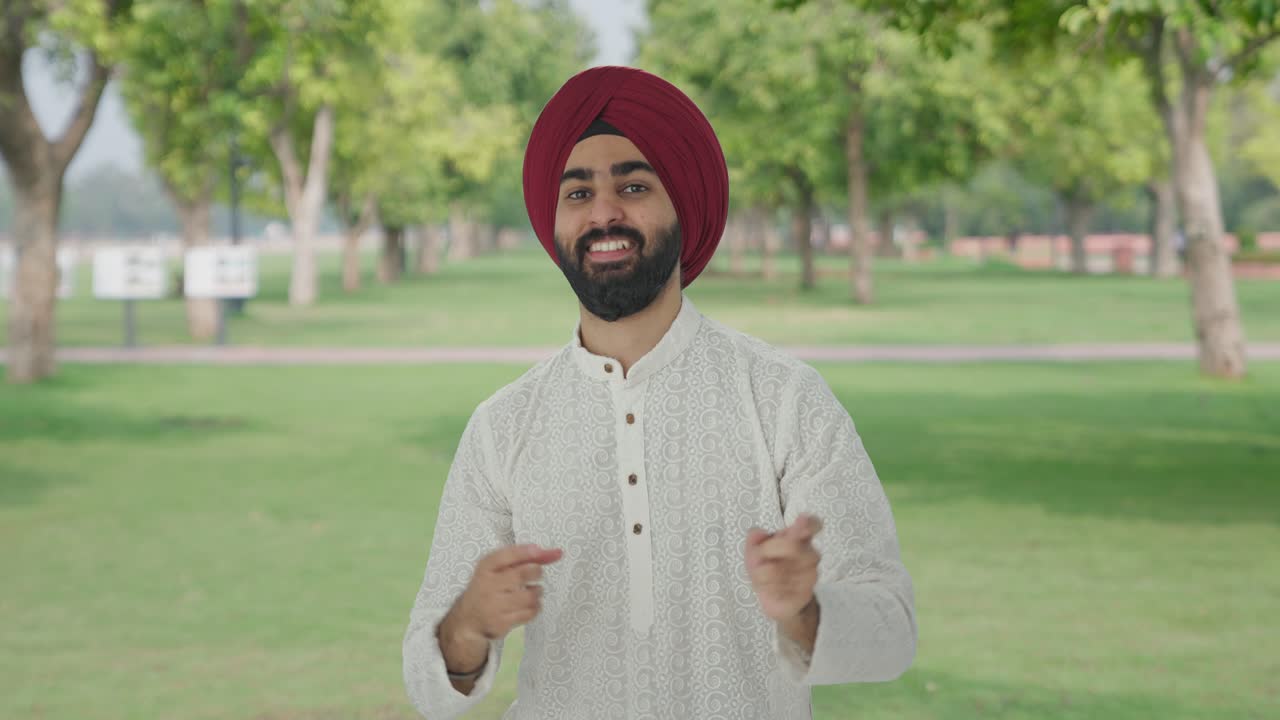 Uomo indiano Sikh felice che balla e si diverte nel parco