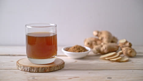 hot and sweet ginger juice glass with ginger roots - healthy drink style