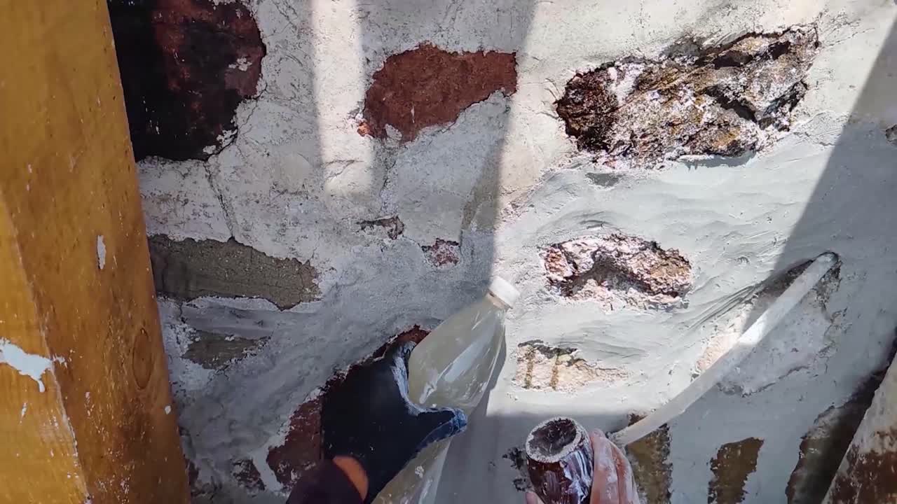 Slowed detail of the polishing process of lime and sand mortar, hydrated with natural mucilage, during the creation of a burnished finish applied to an intervened rock masonry wall in Tepotzotlán, Mx