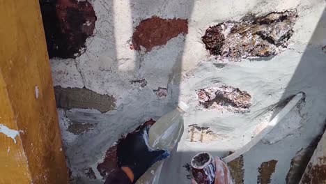 slowed detail of the polishing process of lime and sand mortar, hydrated with natural mucilage, during the creation of a burnished finish applied to an intervened rock masonry wall in tepotzotlán, mx