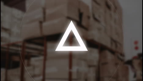 warehouse with stacked boxes, triangle symbol animating over blurred background