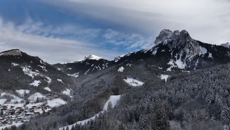 Circular-shot-of-mountain-summit-from-valley-of-pines-with-snow,-Bernex