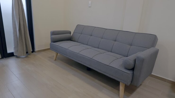 Sofá gris sencillo dentro de la habitación del hotel.