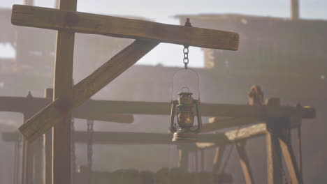 rusty lantern hanging from wooden structure in abandoned area