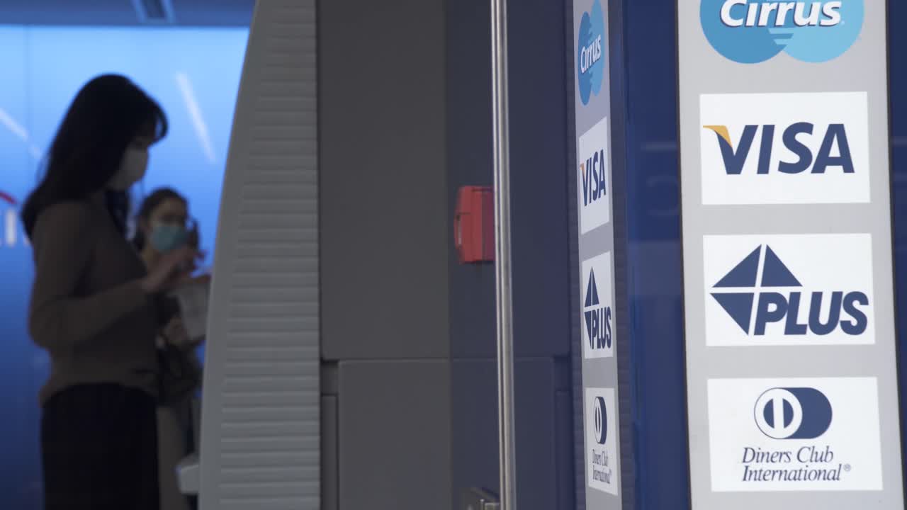 Clients withdraw money from an ATM  machine in Central district, Hong Kong.