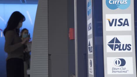 clients withdraw money from an atm  machine in central district, hong kong.