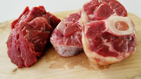 Tres-Trozos-De-Carne-Cruda-Sobre-Una-Tabla-De-Cortar