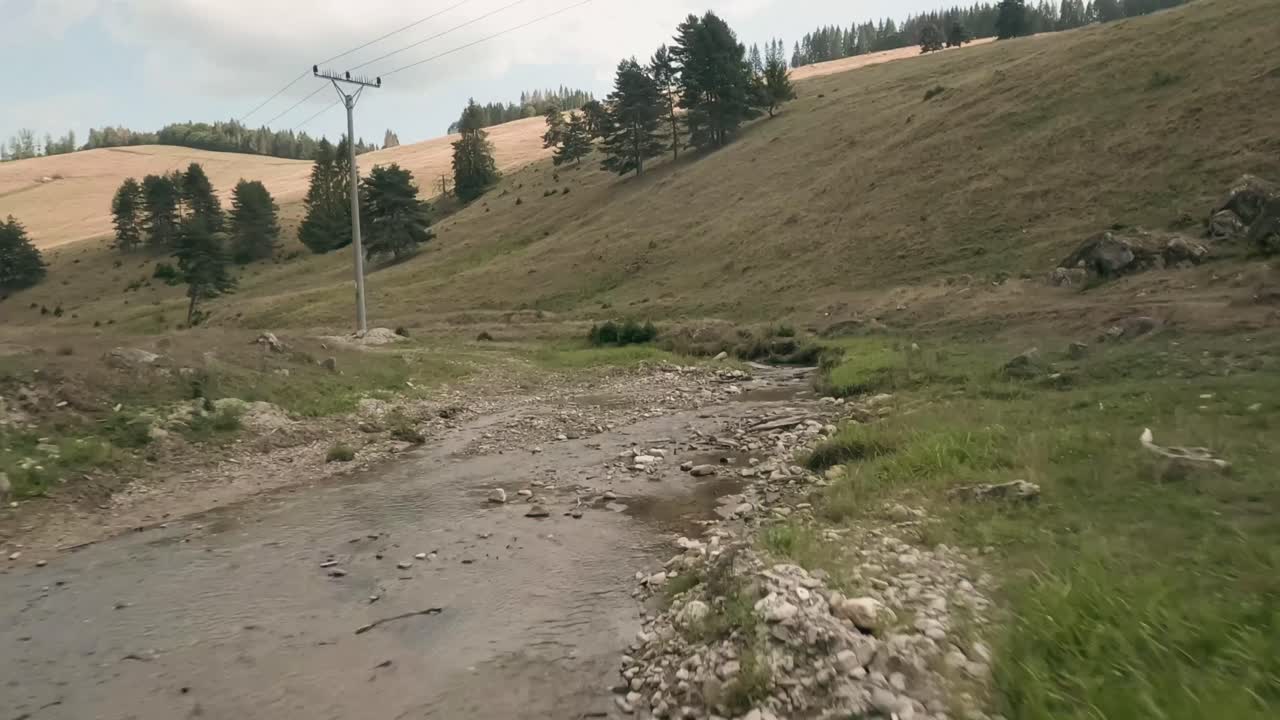 Aerial cinematic footage from FPV racing drone of a creek during a partly cloudy summer day