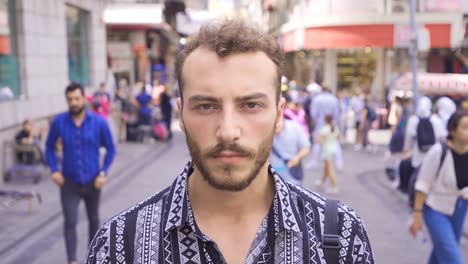 un joven mirando a la cámara en la calle.