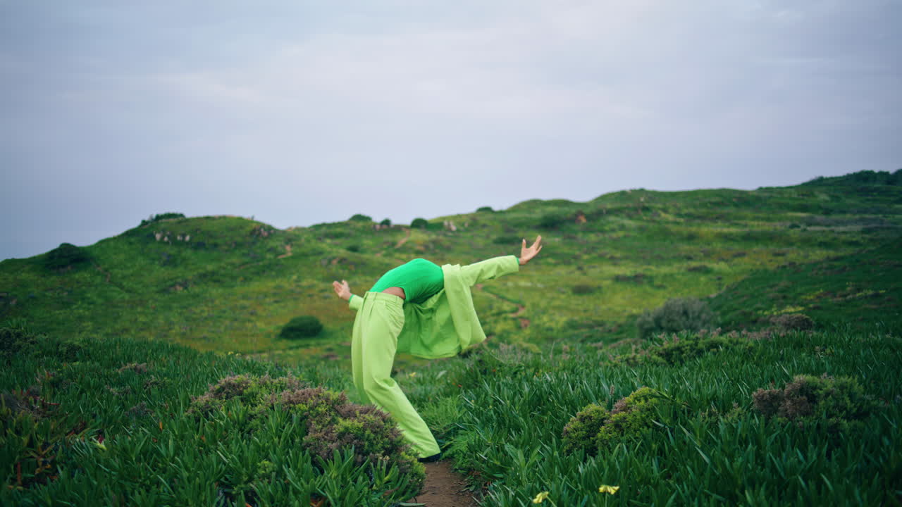 열정적인 소녀 댄서가 구름이 가득한 필드에서 현대적인 스타일을 연주합니다.