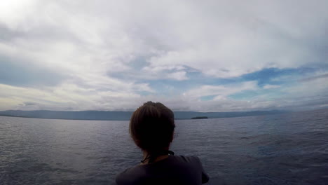 Mujer-Montando-En-La-Parte-Delantera-De-Un-Barco-Durante-Un-Clima-Sombrío