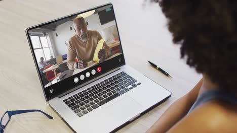 Mujer-Afroamericana-Usando-Una-Computadora-Portátil-Para-Videollamadas,-Con-Un-Colega-De-Negocios-En-La-Pantalla