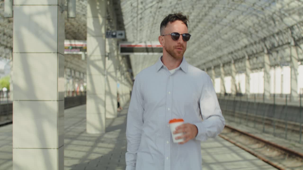 Uomo con caffè alla stazione ferroviaria