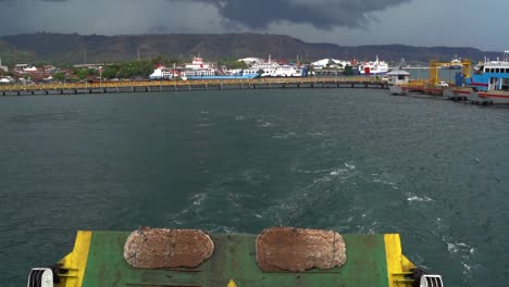 vista hacia atrás desde la parte trasera de un barco frente al puerto mientras un ferry sale de java oriental, en cámara lenta