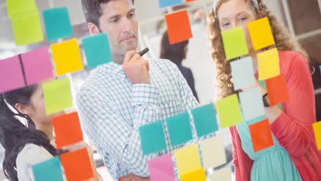 Animation-of-group-of-diverse-business-people-taking-notes-on-glass-wall