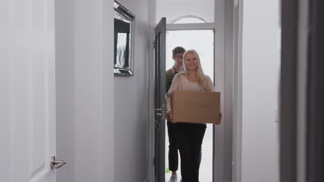 group of college student carrying boxes moving into accommodation together