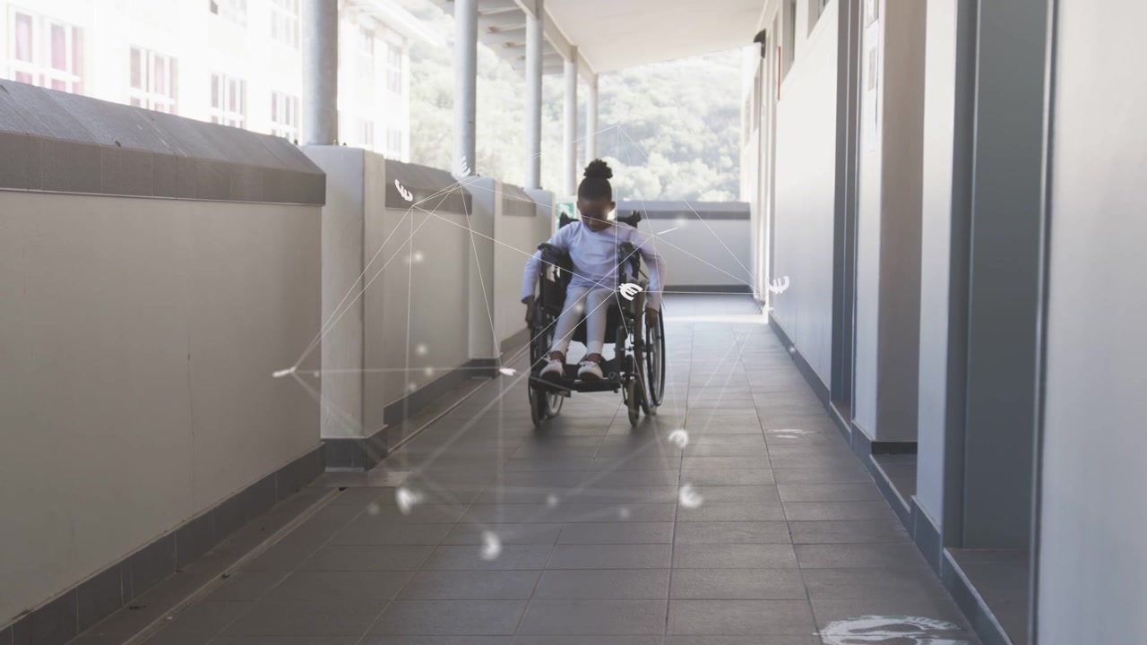 Child pushing wheelchair down corridor gripping rims steering to camera as speckles signal health