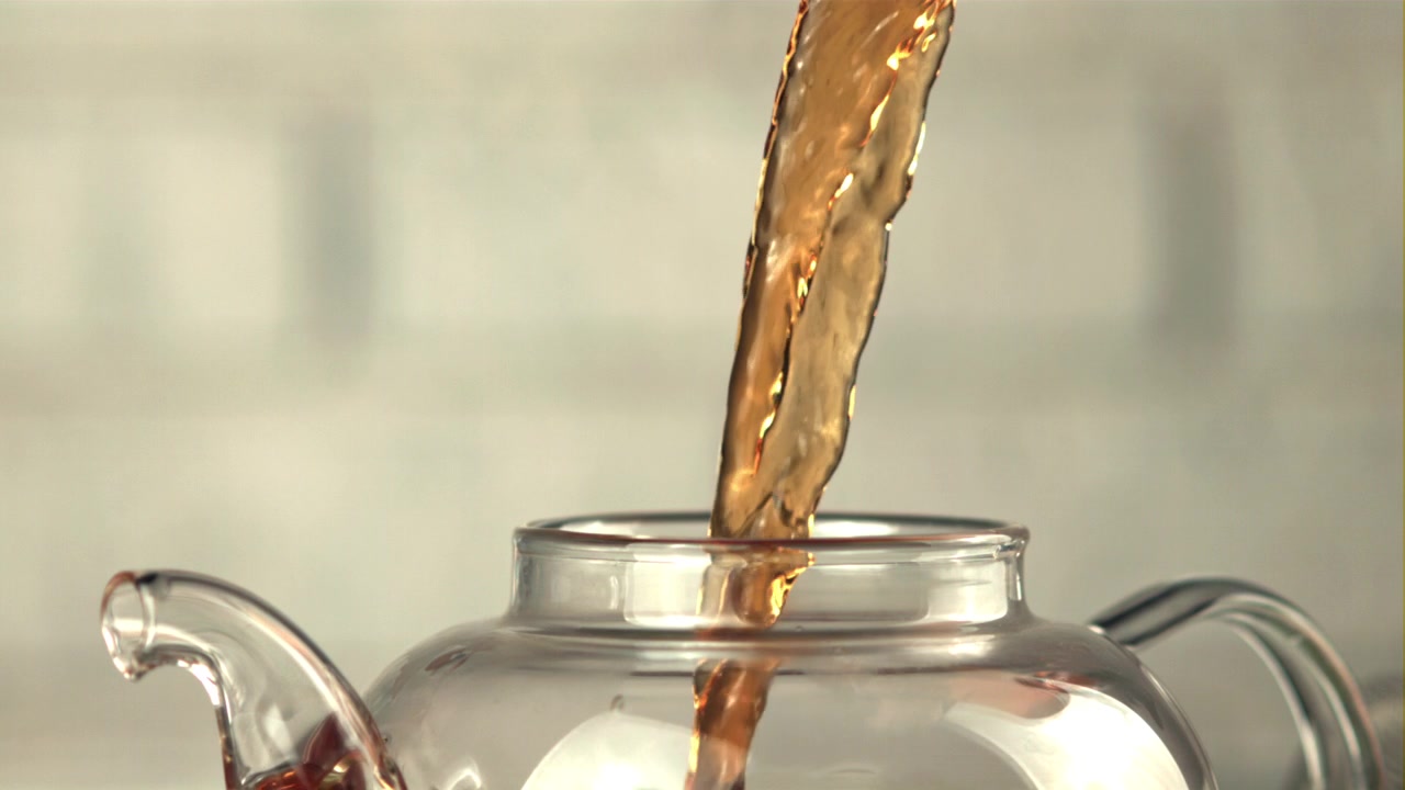 Thé chaud versé dans une théière en verre transparent
