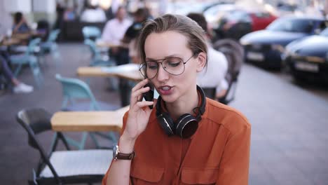 Smartphone-woman-talking-on-phone-while-sitting-in-cafe.-She-is-smiling.-Beautiful-young-female-having-casual-conversation-on