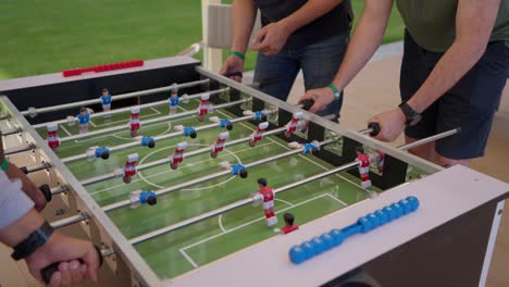 foosball competition between young men in the hall insert shot, close up shot