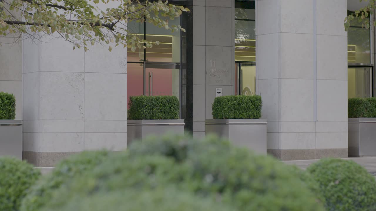 Woman Walking Past Modern Office Building in London