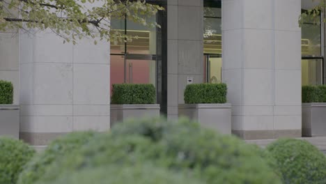 woman walking past modern office building in london
