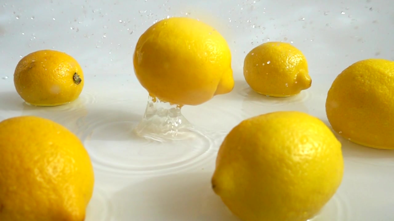 Limone che cade nell'acqua. Movimento rallentato