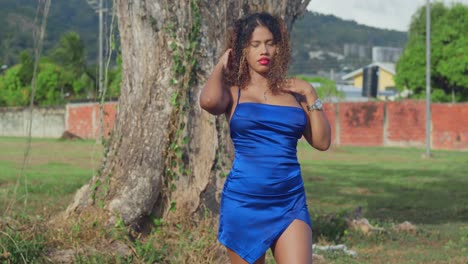 A-young-girl-with-curly-hair-in-a-short-blue-dress-is-enjoying-a-tropical-park-on-the-island-of-Trinidad