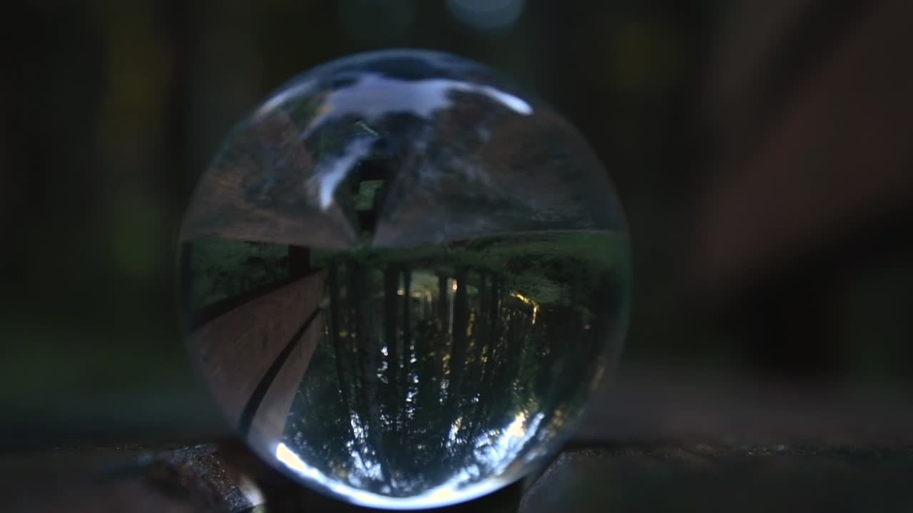 가을과 변덕스러운 풍경을 거꾸로 반영하는 숲 한가운데 벤치에 있는 수정구슬을 닫으세요