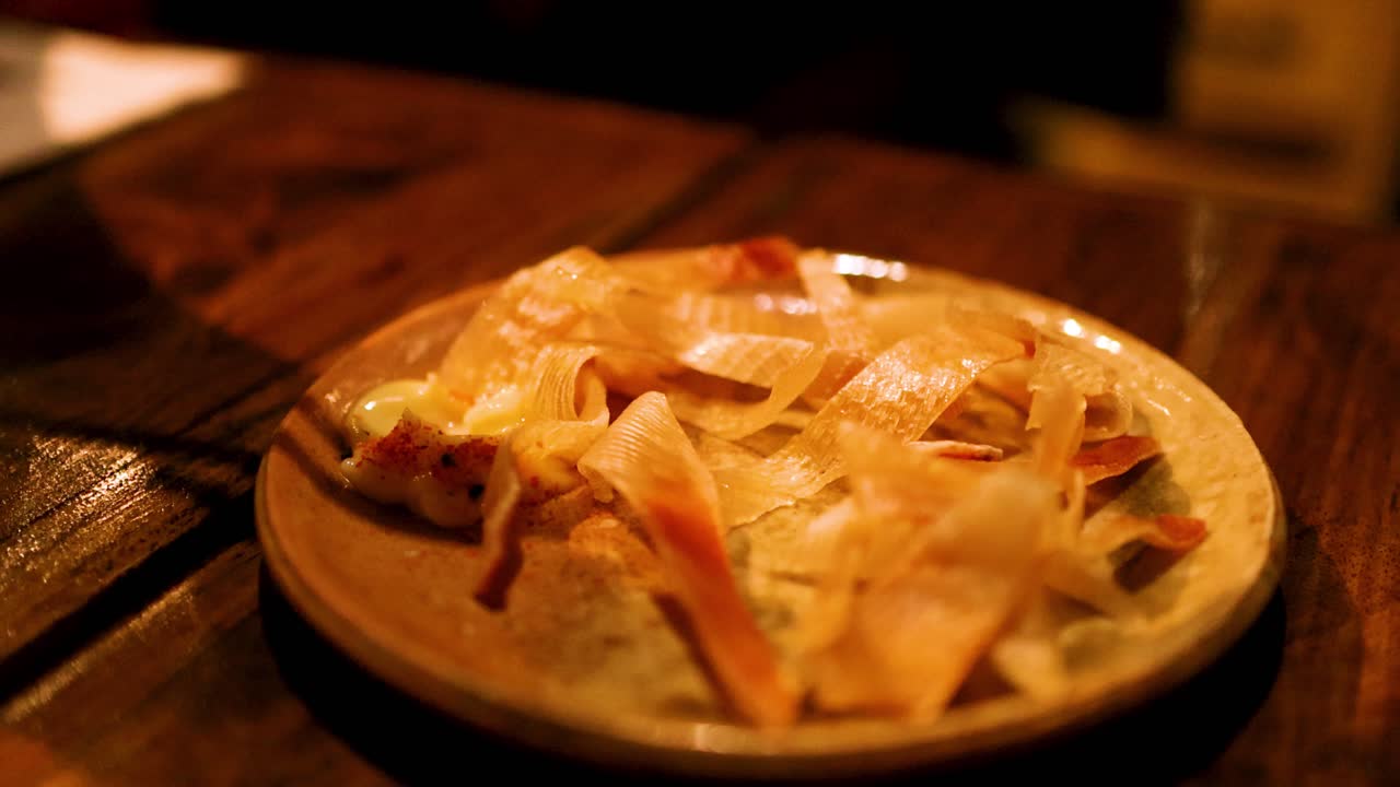 Bacchette che prendono pinna di razza grigliata dal piatto